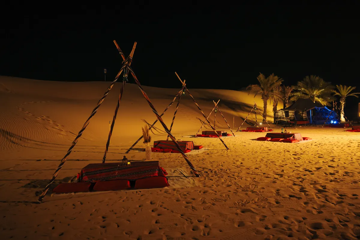 Lanterns and string lights glowing at Khayal Al Sahra camp