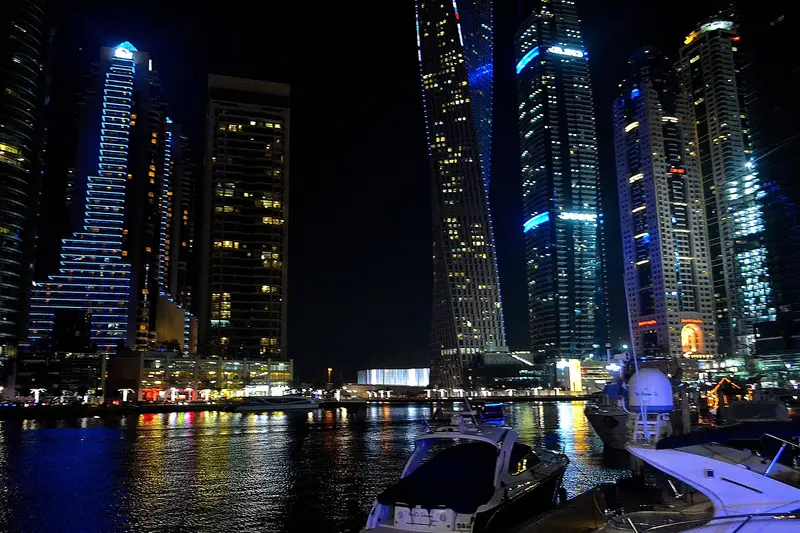 Dubai Marina towers reflected in the water at night